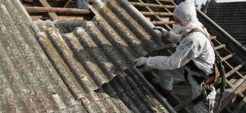 Pracownik usuwający azbest z dachu